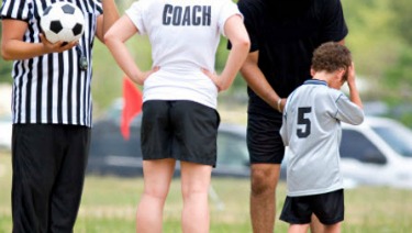 Boy soccer player holding head.